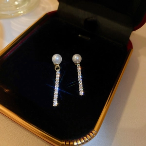 Detail of gold plated pearl earrings with sparkling marquise zircon tassels in a box