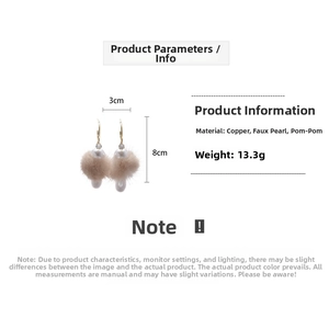 Detail view of water-drop C-shape earrings with beige pom poms and imitation pearls