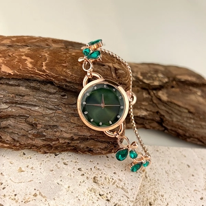 Elegant rose gold watch for women with deep green dial and crystal-embedded leaf bracelet