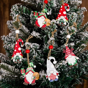 Close-up of wooden Christmas gnome hanging ornaments with red and green painted details