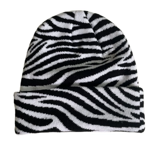 Close-up of zebra pattern knitted beanie showing black and white weaving texture