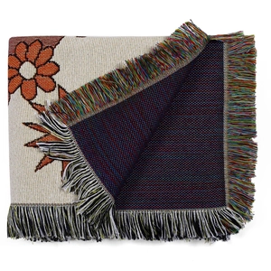 Dettaglio di coperta bohémien intrecciata con motivi floreali arancioni e nappe colorate