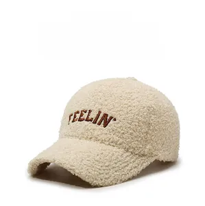 Close-up of beige teddy fleece fabric and brown embroidered FEELIN lettering on baseball cap