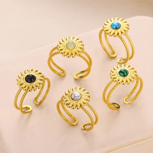 Detail view of five gold sunflower rings with diverse colorful gemstones and adjustable bands
