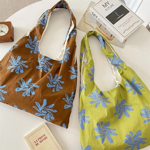 Detail of floral canvas tote bags in blue and green patterns for casual daily use