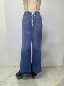 Detalle de pantalones vaqueros de talle alto con cintura elástica y cordón blanco