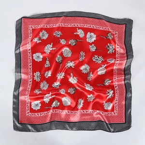 Red square silk scarf featuring white floral patterns and geometric borders for women