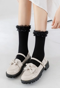 Détail de chaussures Mary Jane blanches à boucle cœur et chaussettes à dentelle