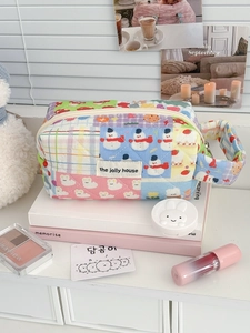 Detail of a quilted multi-color organizer bag with cute cartoon prints and hand strap