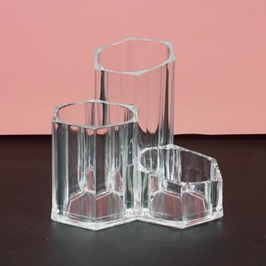 Close-up of clear acrylic hexagonal desktop organizer for lipstick and brushes