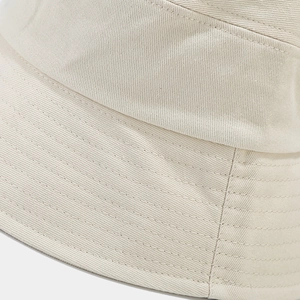 Detailed close-up of beige twill cotton bucket hat showing reinforced stitching lines