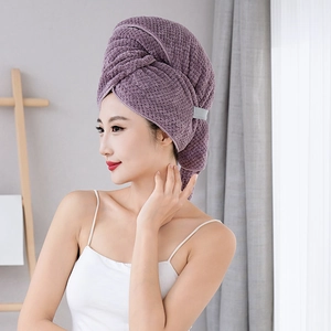 Detail of purple coral fleece hair drying towel showing soft texture on a female model