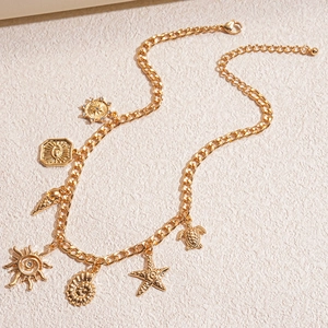 Collana a catena d'oro con ciondoli a conchiglia e stella marina su base strutturata