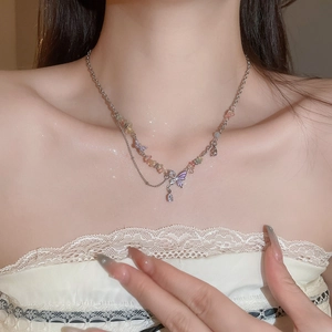 Detail of layered butterfly necklace with colorful crushed stones on female neck