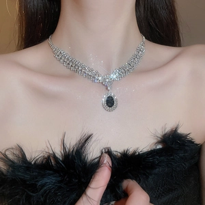 Close-up of elegant multilayer rhinestone necklace with oval black gemstone pendant