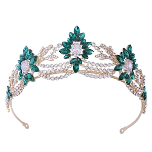 Close-up of golden bridal crown with sparkling clear and emerald green crystals