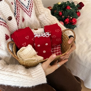 Detailed view of red cotton socks with heart and floral patterns in a festive basket