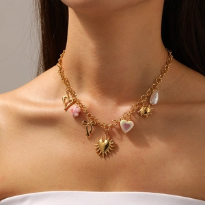 Goldene Edelstahlperlenkette mit Herz- Schleife- und Sonnenanhängern am weiblichen Modell