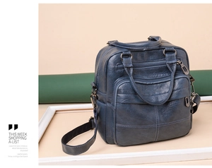 Detail view of deep blue textured faux leather backpack showing multiple front zipper pockets