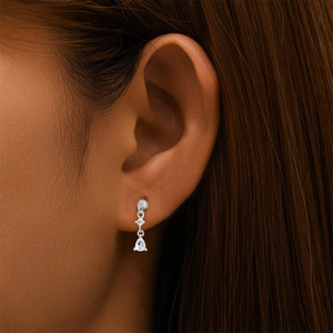 Gros plan d'une boucle d'oreille en argent avec pendentif zircon goutte sur un mannequin