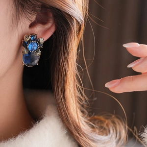 Nahaufnahme der Vintage-Ohrstecker mit blauen Kristallen und Blumenmuster