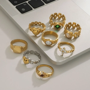 Eight-piece gold and silver fashion ring set featuring emerald, pearl, and zircon details