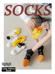 Detail of cute yellow duck cartoon socks in yellow, white and black cotton fabric