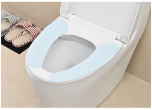 Dettaglio del copriwater adesivo azzurro morbido su tazza in ceramica bianca pulita