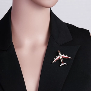 Detail of red and white airplane brooch on a black suit lapel with golden metal base