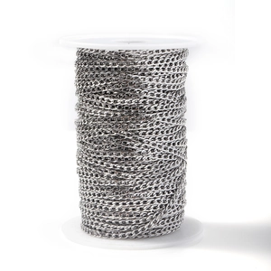 Close-up of polished silver stainless steel Cuban link chain on a spool for DIY jewelry