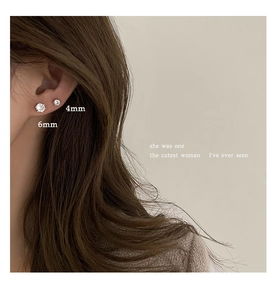 Detailed comparison of 4mm and 6mm round sparkling zircon stud earrings on model ear