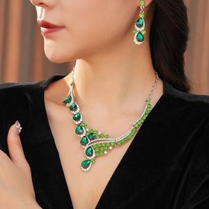 Detailed view of model wearing vintage green crystal waterdrop necklace and earrings set