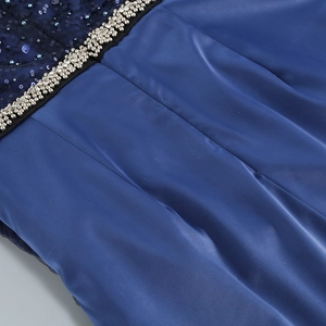 Détail des paillettes bleu foncé et strass sur la taille d'une robe de soirée