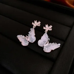 Elegant silver butterfly earrings with zircons and floral studs on black velvet