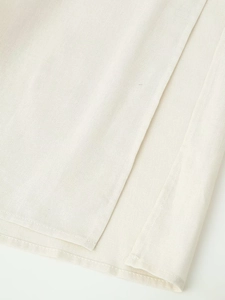 Makrodetail der beigen Baumwoll-Leinen-Stoffstruktur und der Schlitznaht am Kleid