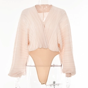 Detail showing the pleated pink deep V-neck bodice and light tan high-cut bodysuit base