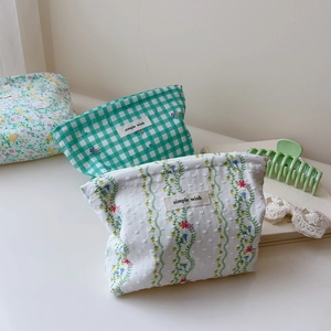 Detail of floral and green checkered cotton makeup bags with simple wish woven label