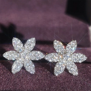 Macro view of sparkling zircon butterfly heart stud earrings on purple velvet background