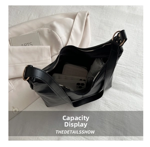 Macro view showing large capacity interior of black leather tote bag with daily essentials