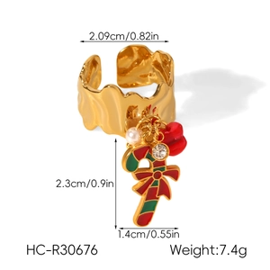 Detail of Christmas ring with gold candy cane, red bow, pearl, and rhinestone pendant