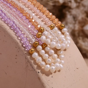 Macro shot of colorful faceted crystal beads, freshwater pearls and gold steel beads