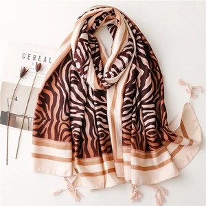 Brown and cream zebra print silk scarf with tassels displayed on a white stylish tabletop