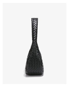 Detailed view of black woven faux leather texture and handcrafted handle of the bag