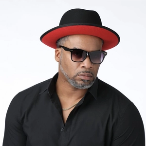 Close-up of stylish black fedora with contrast red brim, gold chain and sunglasses