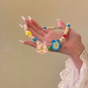 Detail of handmade beaded necklace with colorful tropical flowers and sparkling crystals