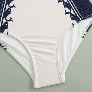 Close-up of white swimwear showing blue bohemian patterns and elastic ruched fabric detail