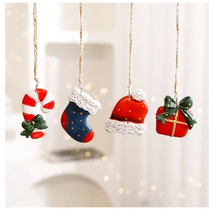 Close-up of resin Christmas ornaments featuring a mini candy cane, sock, hat, and gift box