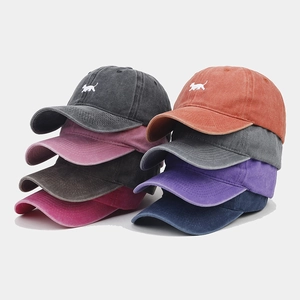 Gros plan d'une collection de huit casquettes vintage en coton délavé avec broderie chien