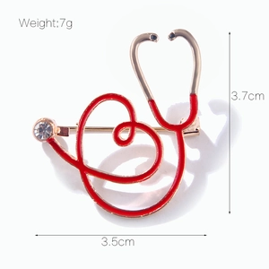 Détail de la broche stéthoscope coeur rouge avec dimensions 3,5x3,7cm et un poids de 7g
