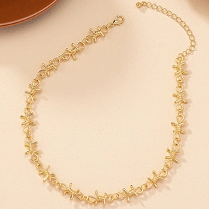 Close-up of golden barbed wire necklace with lobster clasp and adjustable extension chain